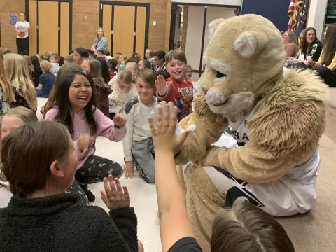 Cosmo the Cougar giving students a high five